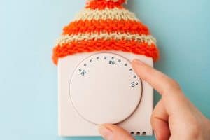 furnace thermostat on wall with little hat